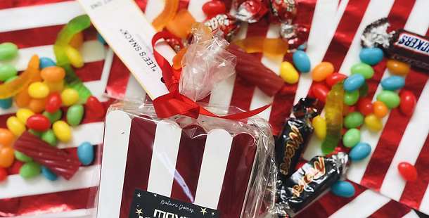 A striped popcorn and lolly box with mixed lollies and chocolates