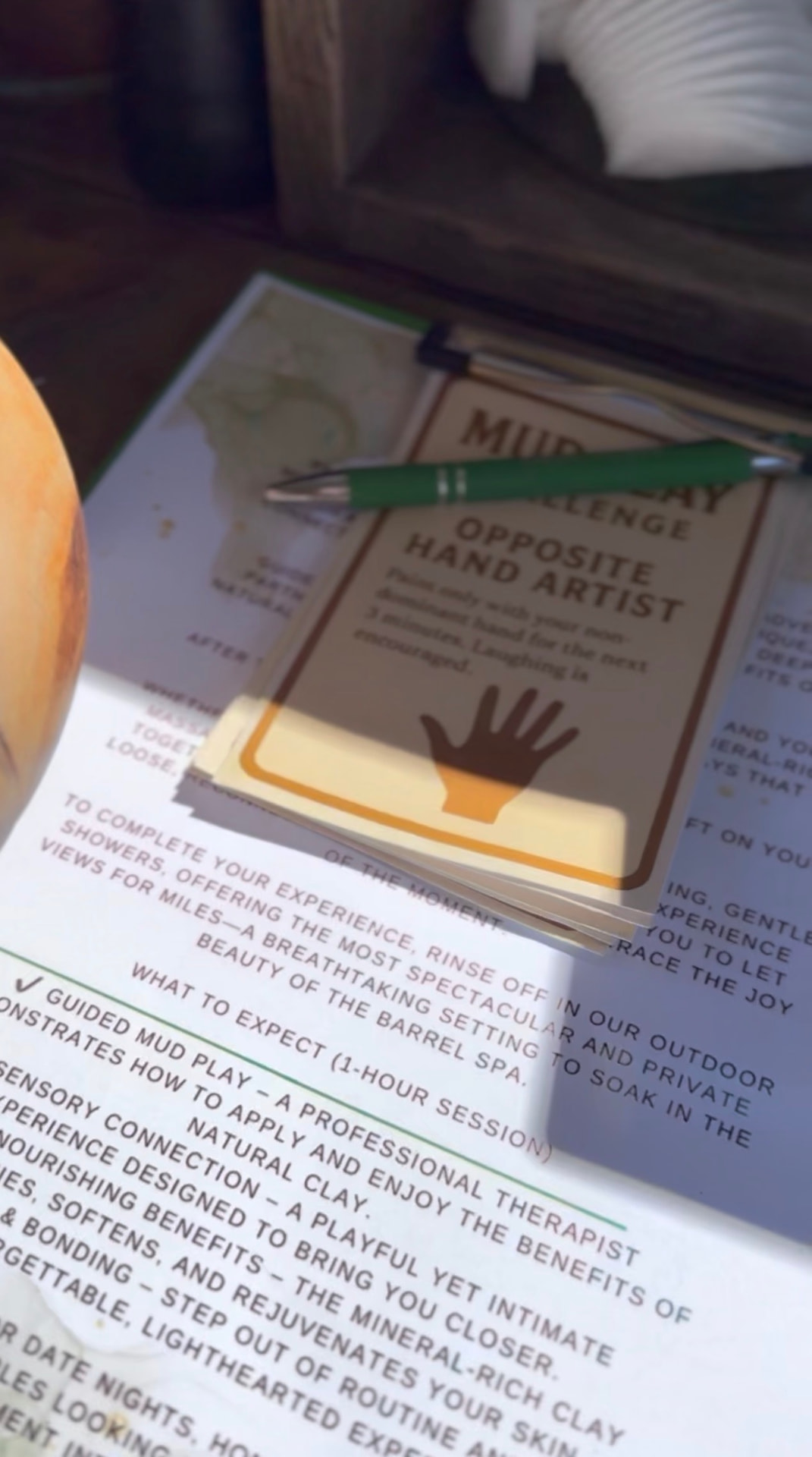 A mud clay challenge card reading Opposite Hand Artist resting on the Couples' Mud Play experience notes