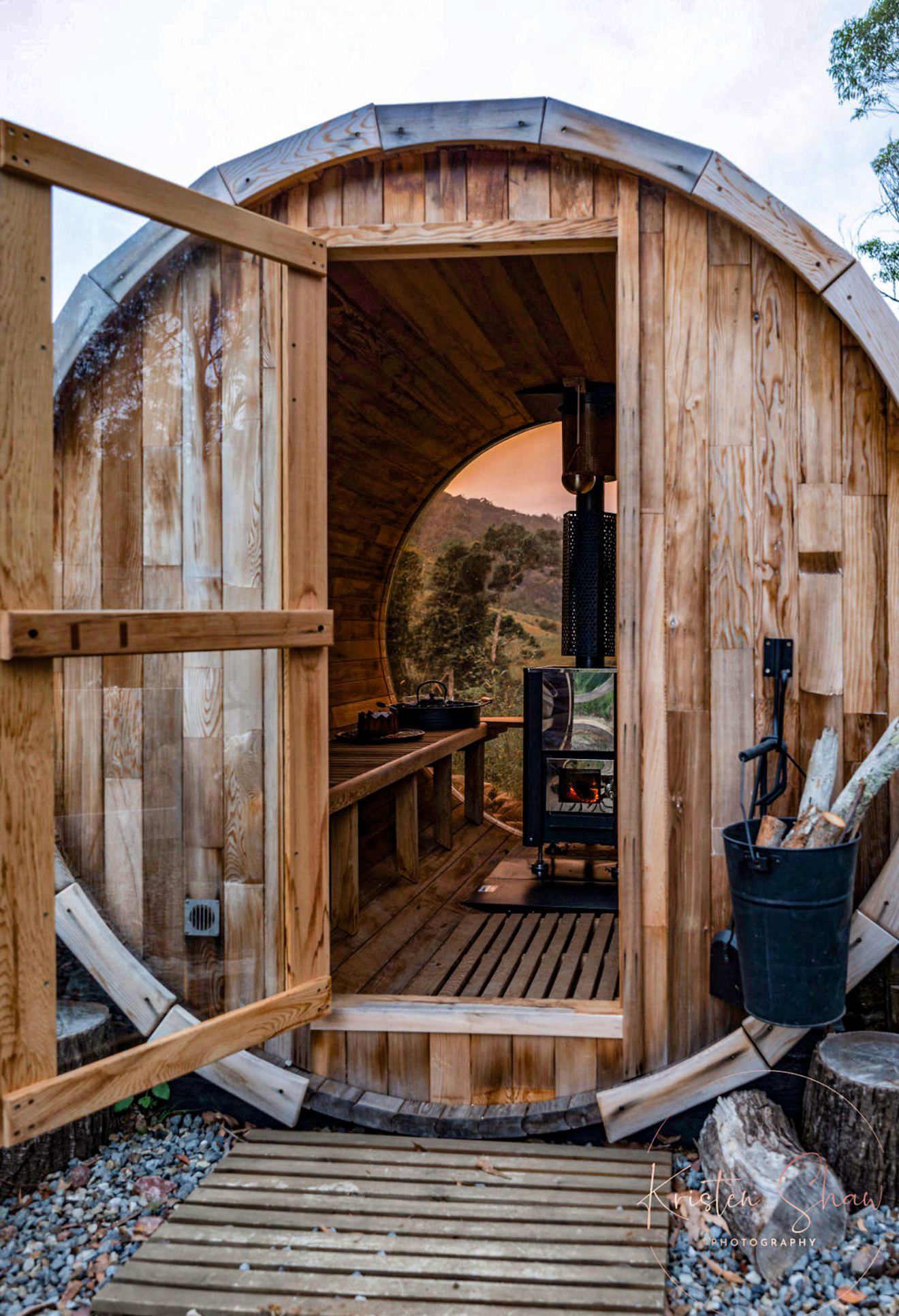 The cedar barrel sauna with a round window looking out over the ranges
